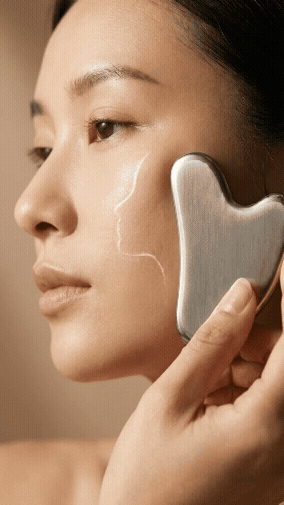 The Luminae gua sha resting against skin, captured mid-ritual